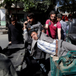 Men move an injured man to a hospital after a blast in Kabul, Afghanistan