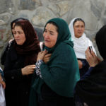 Afghan women mourn outside a hospital after a blast in Kabul, Afghanistan