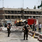 Afghan officials inspect outside the German embassy after a blast in Kabul, Afghanistan
