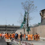 Afghan municipality workers sweep a road outside the German embassy after a blast in Kabul, Afghanistan