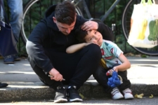 A man comforts a boy after a tower block was severly damaged by a serious fire, in north Kensington, West London