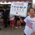 Madelyn del Rio, from Dominican Republic, holds a sign up in front of the Cuban popular Cafe Versailles in the Little Havana district as U.S. President Donald Trump is expected to announce changes to U.S.-Cuba policy, in Miami